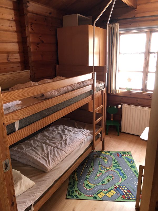 Kinderzimmer mit Etagenbett und Spielteppich