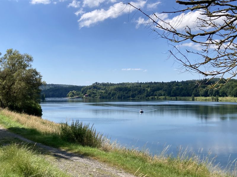 Twistesee mit einem Boot und einem Fußweg am Ufer unter blauem Himmel
